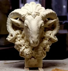 a sculpture of a ram with flowers on it's head