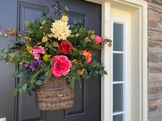 a basket filled with flowers hanging from the side of a door