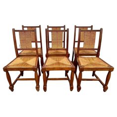 four wooden chairs with woven seats on them