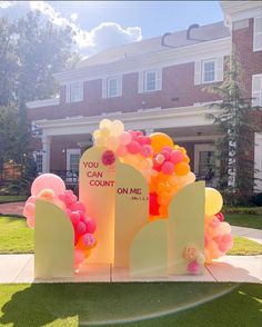 a couple of tombstones with balloons on them in front of a large brick building