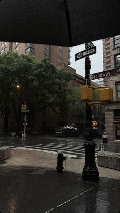 the street sign is clearly visible for us to see in this view from under an umbrella