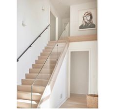 a staircase with glass railing and wooden handrail