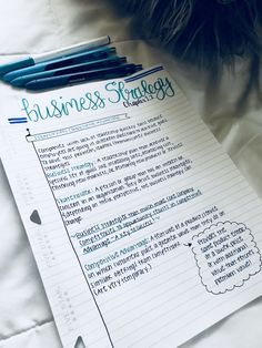 a paper with writing on it next to some pens