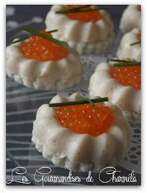 small crackers with orange cavia on them sitting on a glass plate in front of the camera