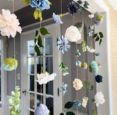 paper flowers hanging from strings in front of a door