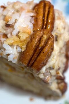 there is a piece of cake with pecans on top and coconut flakes on the bottom