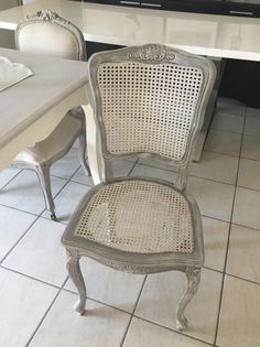 two chairs sitting next to each other on a tile floor in front of a counter