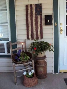 an american flag hanging on the side of a house next to a potted plant