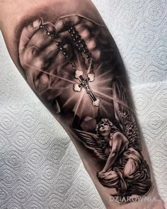 a black and white tattoo on the arm of a person holding a rosary with an angel