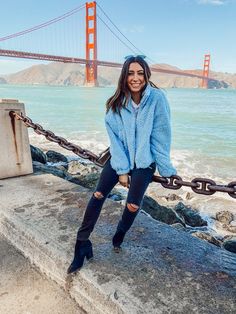 a woman posing for a photo in front of the golden gate bridge