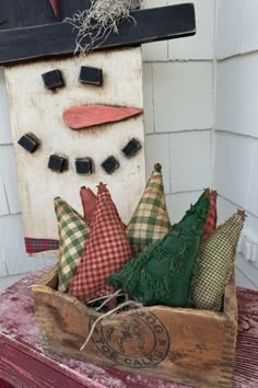 a wooden box filled with pillows sitting on top of a table