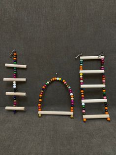 the word bead spelled out with different colored beads and wooden pegs on a gray background