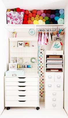 an organized closet with white drawers and lots of crafting supplies on top of it