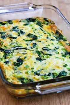 a casserole dish with spinach and cheese in it on a wooden table