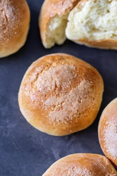 several rolls with powdered sugar on them sitting on a blue tablecloth next to each other