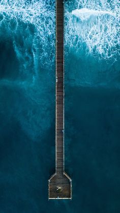 an aerial view of a pier in the ocean