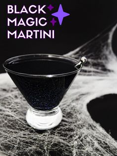 a black magic martini in a glass on top of a table