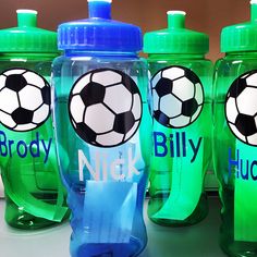 three green sports bottles with soccer balls on the lids and one has a blue cap