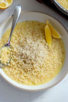 a bowl of soup with lemons and parmesan cheese on the side, ready to be eaten