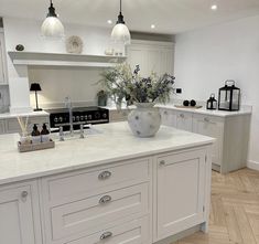 a large kitchen with white cabinets and marble counter tops, an island in the middle