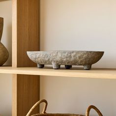 two vases and a bowl sitting on top of a shelf next to each other