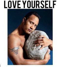 a man holding a large rock with the words love yourself written on it in front of him