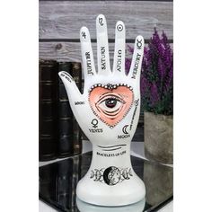 a white ceramic hand with an eye on it and words written all over the palm