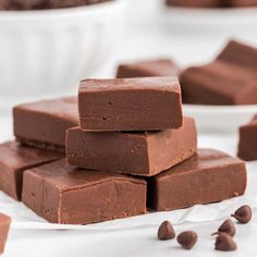 chocolate fudges stacked on top of each other in front of a cutting board