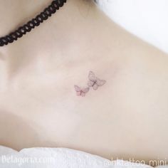 a woman's chest with two small butterflies on her left side, and the upper part of her breast visible