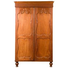 an old wooden armoire with carvings on the front and side panels, isolated against a white background