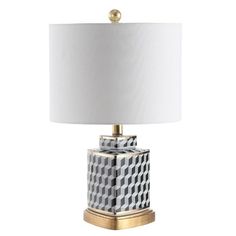 a table lamp with a white shade on the top and gold trimming around it