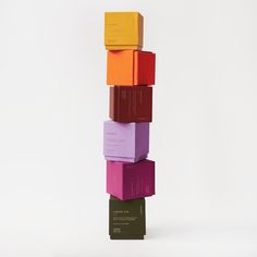 a stack of colorful boxes sitting on top of each other in front of a white background