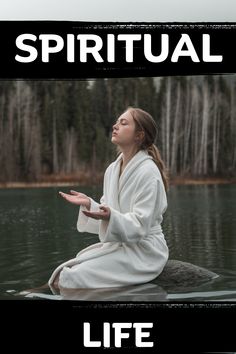 a woman sitting on top of a rock in the water with her hands out to pray