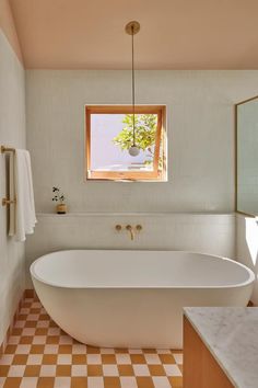 a large white bath tub sitting under a window