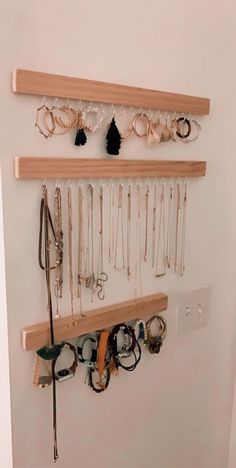 a wall mounted jewelry rack with several necklaces