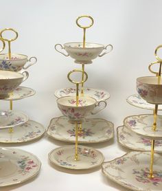 there are many cups and saucers stacked on each other with gold rings at the top