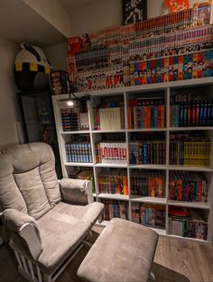 a chair and ottoman in front of a bookshelf full of comic books on shelves