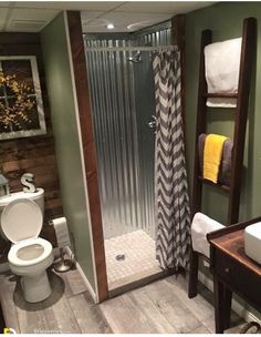 a bathroom with a toilet, shower and towel rack in it's corner next to a sink