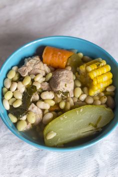 a blue bowl filled with beans and vegetables