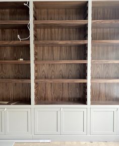 an empty bookshelf in the corner of a room with no one on it