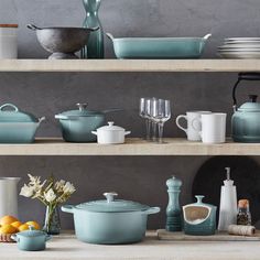 various pots and pans on shelves in a kitchen