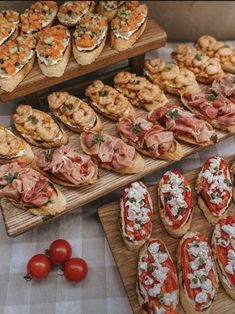 a table topped with lots of different types of breads and pastries on wooden trays