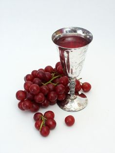 grapes and a chalicette on a white table