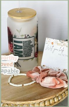 a candle, necklace and card on a table