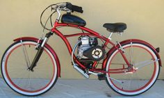 a red and white bicycle parked next to a wall