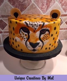 a cheetah cake is decorated with yellow and black icing