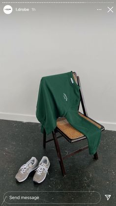 a pair of tennis shoes sitting on top of a chair next to a green blanket