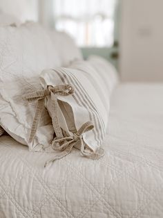 a white bed topped with pillows and a pillow on top of it's side