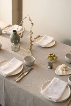 the table is set with plates, silverware and other things to eat on it