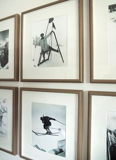 black and white photographs hang on the wall above a chair with skis in it